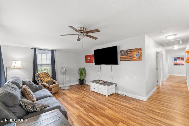 living room with ceiling fan, light hardwood / wood-style floors, and a textured ceiling