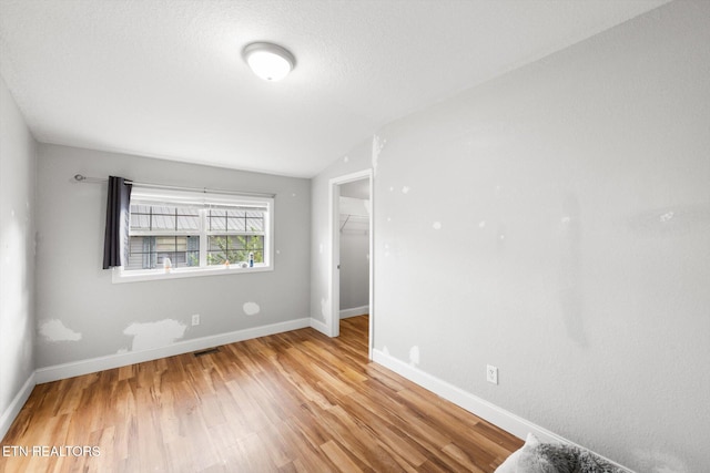 empty room with light hardwood / wood-style floors and lofted ceiling