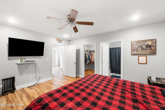 bedroom with hardwood / wood-style floors, a spacious closet, a closet, and ceiling fan