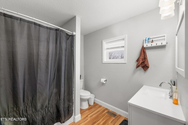 bathroom featuring hardwood / wood-style flooring, vanity, curtained shower, and toilet