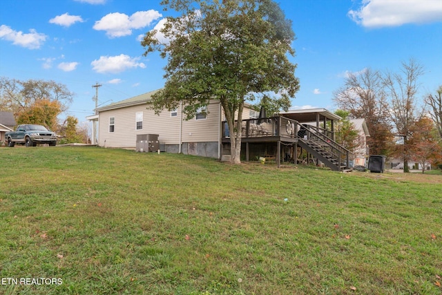 rear view of property featuring a yard and a deck