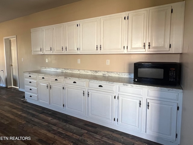 interior space featuring dark hardwood / wood-style floors and white cabinets