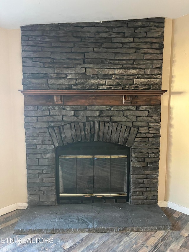 interior details with a stone fireplace and hardwood / wood-style floors