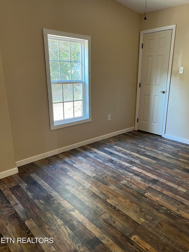 unfurnished room featuring dark wood-type flooring and ceiling fan