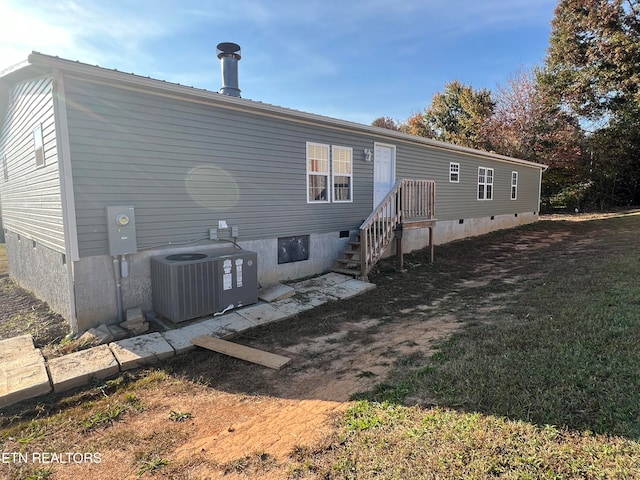 rear view of property with central AC