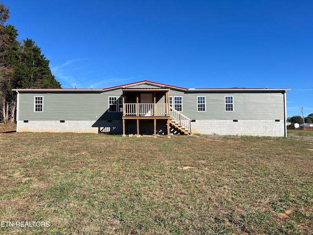 rear view of property with a lawn and a deck