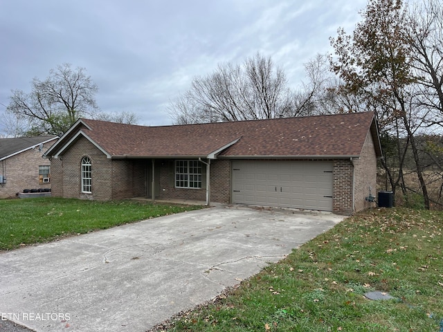 ranch-style house with central AC unit, a garage, and a front yard