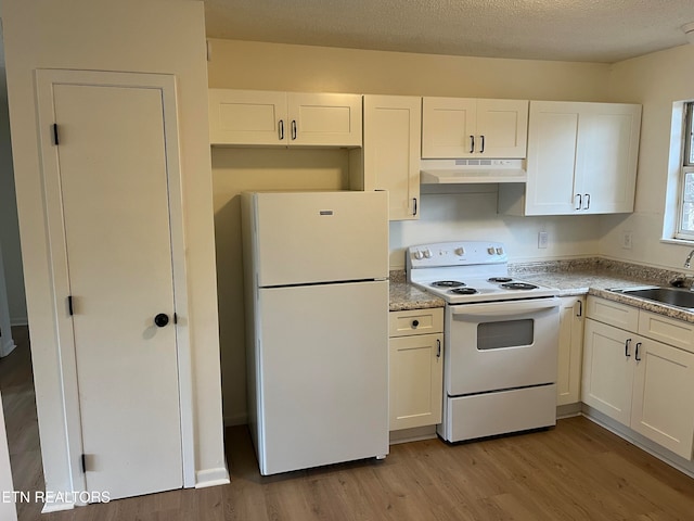 kitchen with white appliances, white cabinetry, sink, and light hardwood / wood-style floors