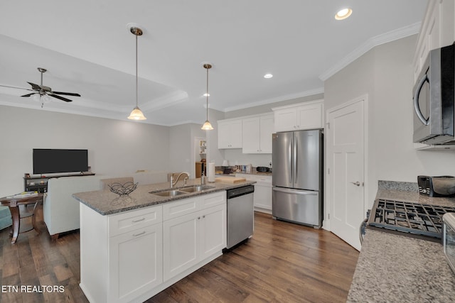 kitchen featuring appliances with stainless steel finishes, dark hardwood / wood-style floors, sink, an island with sink, and white cabinets