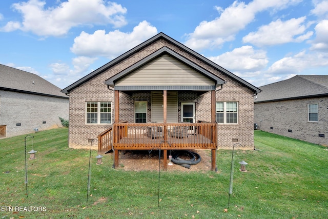 rear view of property with a wooden deck and a yard