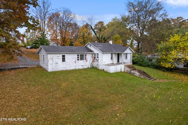 rear view of property featuring a lawn