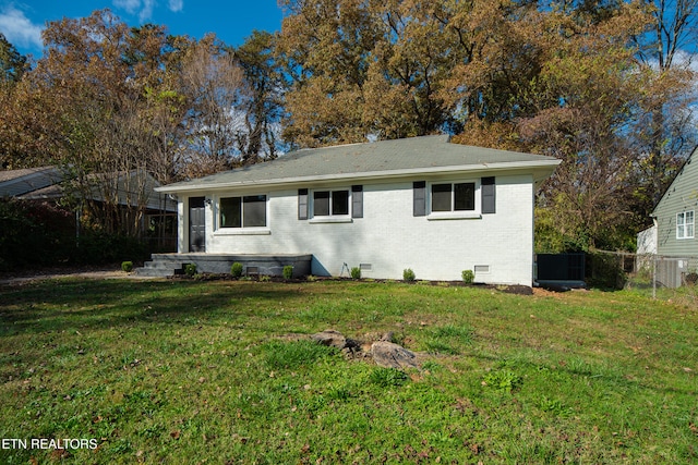 back of property featuring central AC and a yard