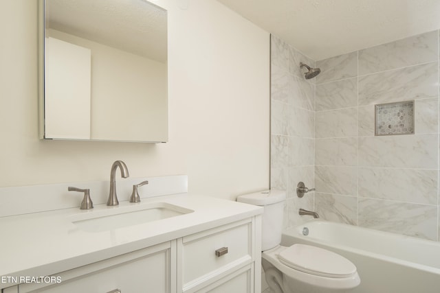 full bathroom with toilet, vanity, tiled shower / bath, and a textured ceiling