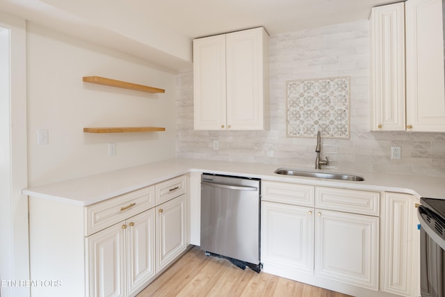 kitchen featuring appliances with stainless steel finishes, decorative backsplash, sink, white cabinets, and light hardwood / wood-style flooring