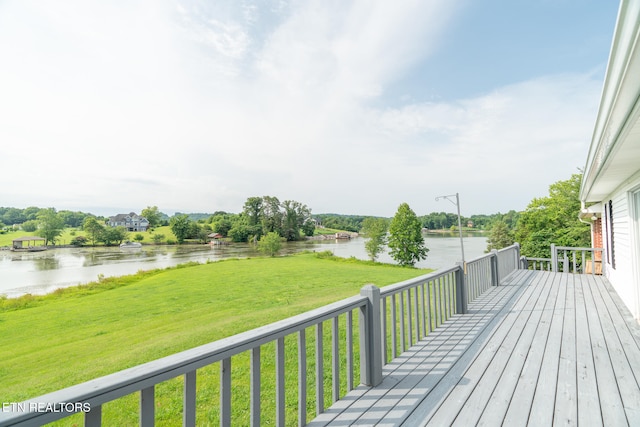 deck with a yard and a water view