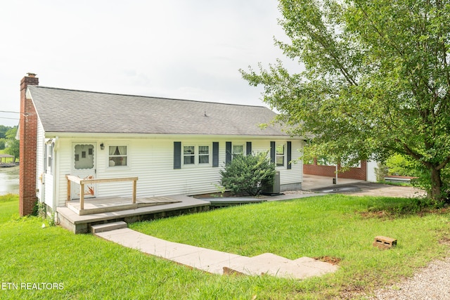 ranch-style house featuring a front lawn and a deck