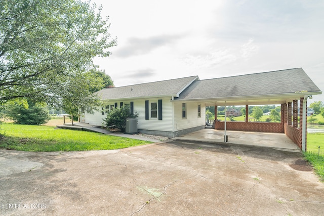 ranch-style home with a carport, a front lawn, and cooling unit