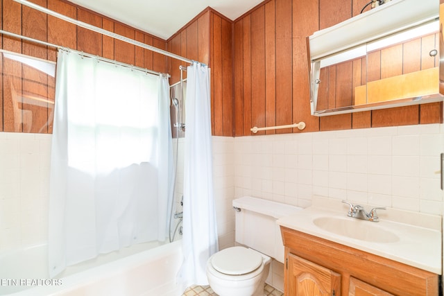 full bathroom featuring tile walls, vanity, toilet, and shower / tub combo with curtain