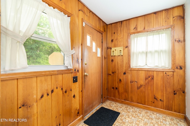 doorway to outside featuring wood walls