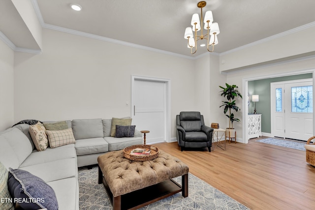 living room featuring crown molding, a chandelier, and hardwood / wood-style flooring