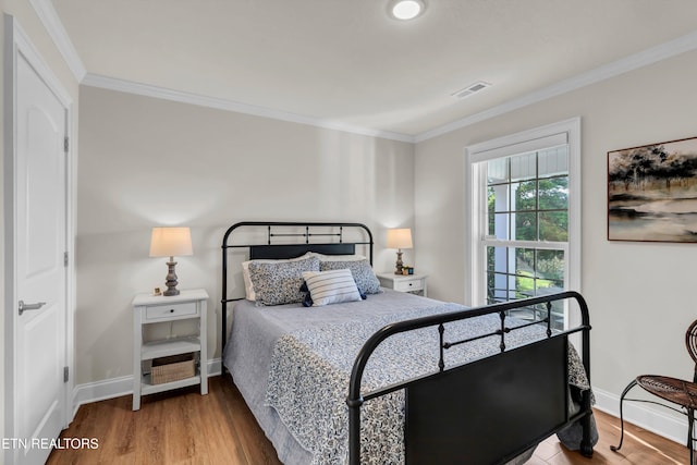 bedroom with wood-type flooring and ornamental molding