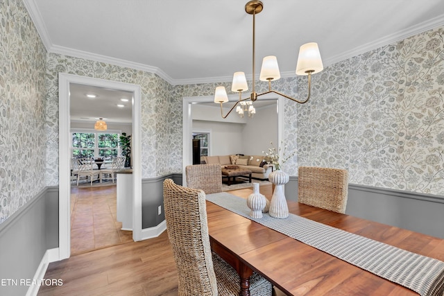 dining room with a chandelier, wood-type flooring, and ornamental molding