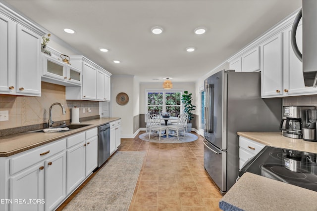 kitchen featuring white cabinets, decorative backsplash, stainless steel dishwasher, and sink