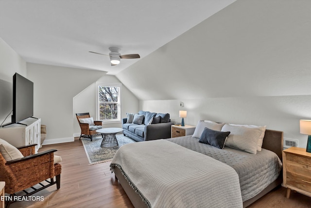 bedroom with ceiling fan, light hardwood / wood-style floors, and lofted ceiling