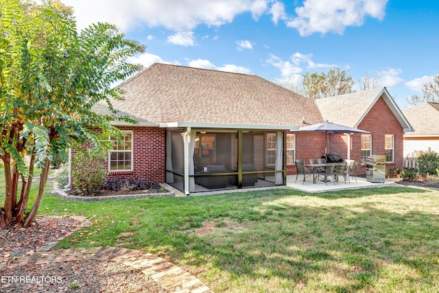 back of property with a yard, a patio, and a sunroom