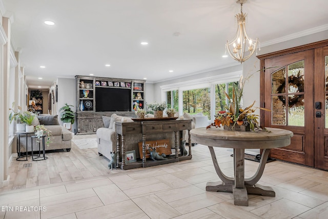 living room featuring light wood-type flooring, a notable chandelier, and crown molding