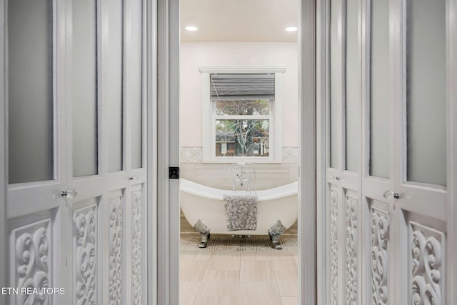 bathroom featuring a tub and tile walls