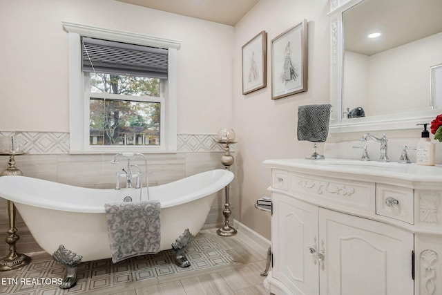 bathroom with tile walls, a bathtub, and vanity