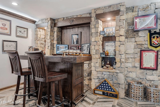 bar with parquet floors and ornamental molding