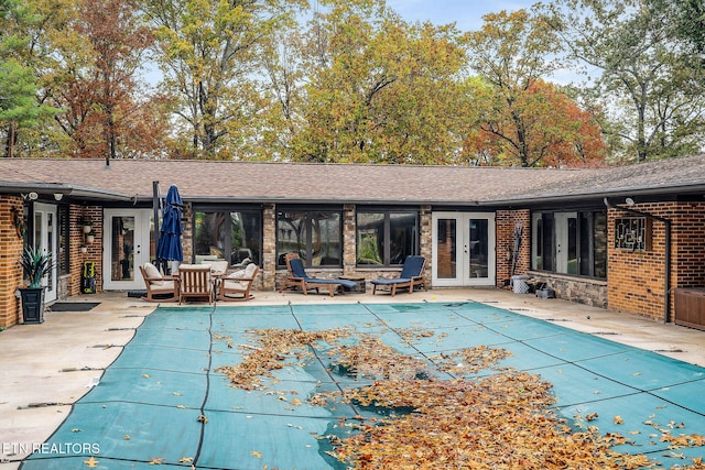 view of swimming pool featuring a patio and french doors