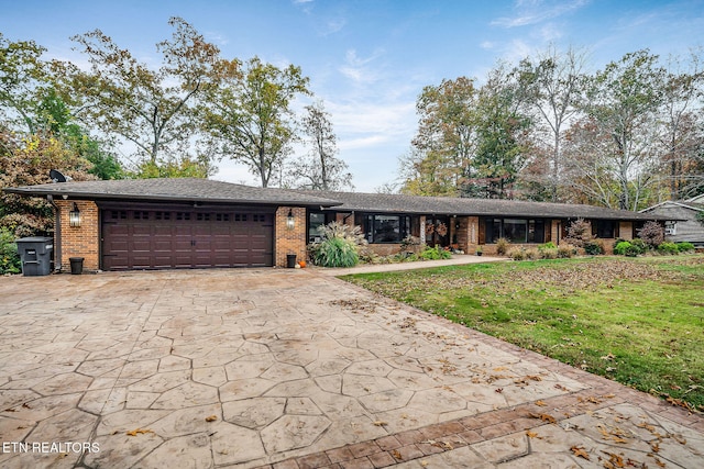 single story home featuring a front lawn and a garage