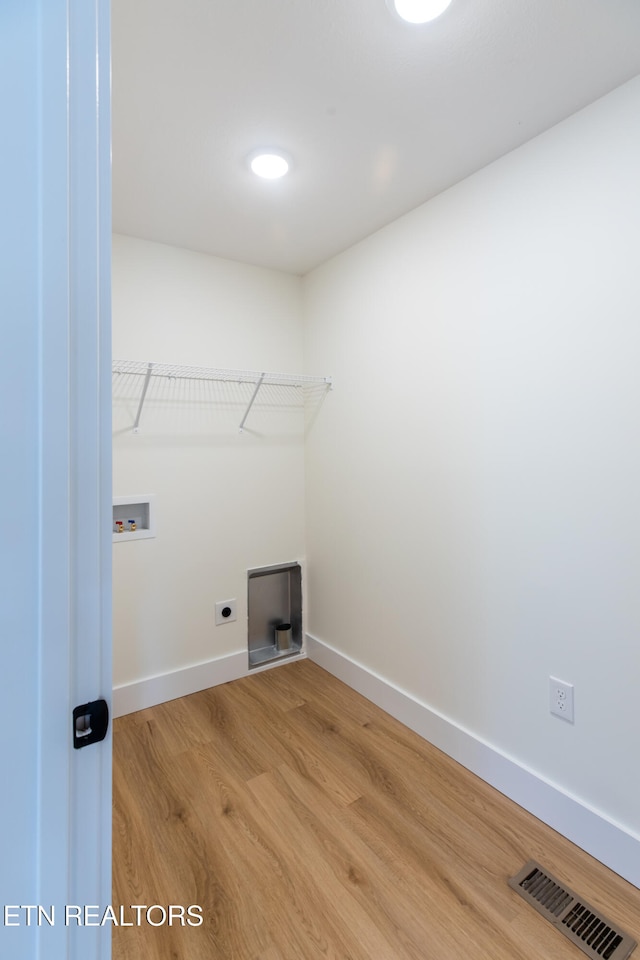 clothes washing area featuring hardwood / wood-style floors, hookup for a washing machine, and electric dryer hookup