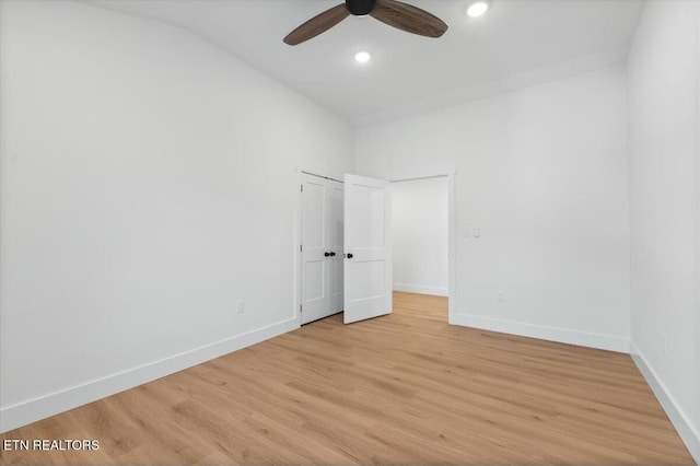 unfurnished bedroom featuring ceiling fan, lofted ceiling, and light wood-type flooring