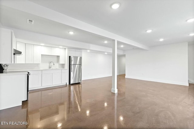 basement with stainless steel fridge and sink