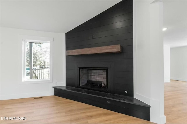 room details featuring a large fireplace and hardwood / wood-style floors