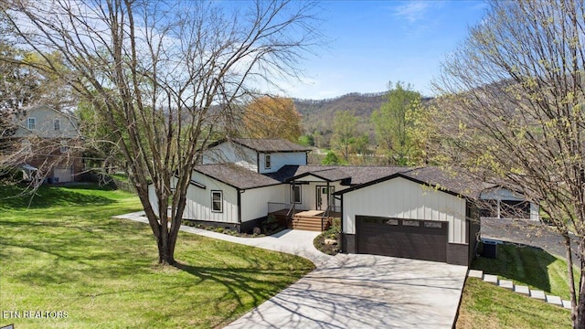 view of front of property with concrete driveway, a front yard, and an attached garage