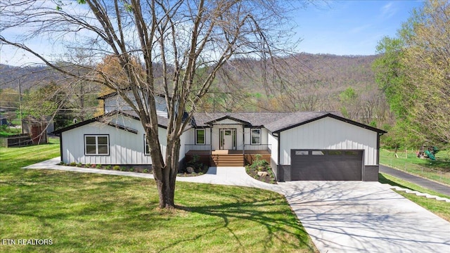 view of front facade with a front yard, driveway, and a garage