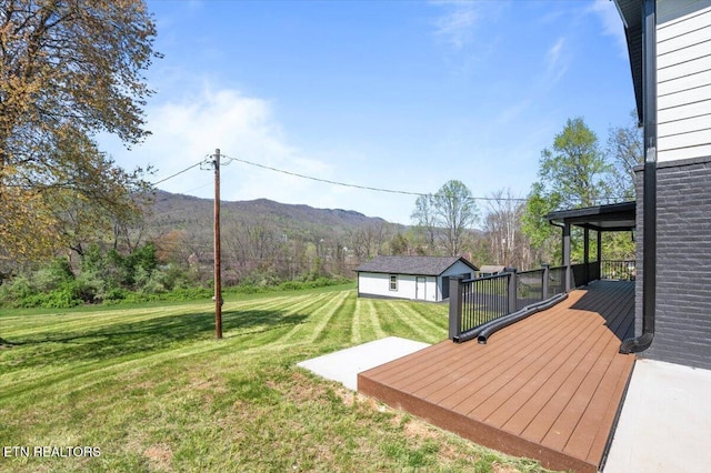 view of yard with an outbuilding and a deck with mountain view