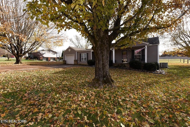 view of front of home featuring a garage, a front lawn, and central air condition unit