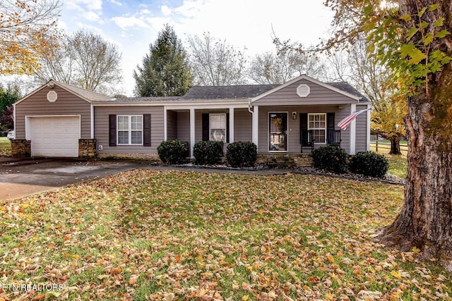 ranch-style house with covered porch, a garage, and a front lawn