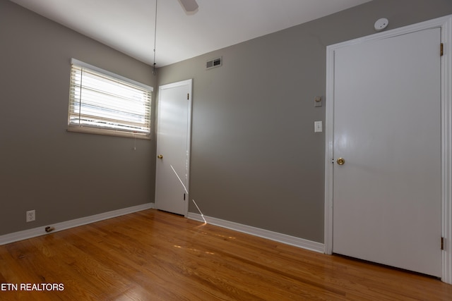 spare room with ceiling fan and light wood-type flooring