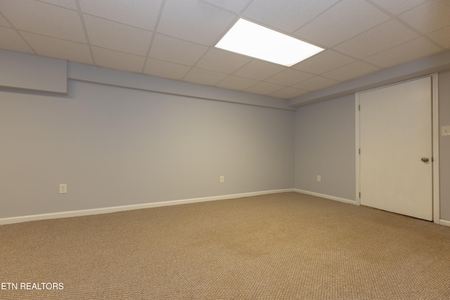 basement featuring carpet and a drop ceiling