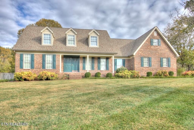 cape cod-style house with a front yard