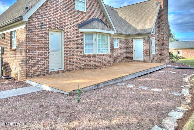 rear view of house featuring a wooden deck