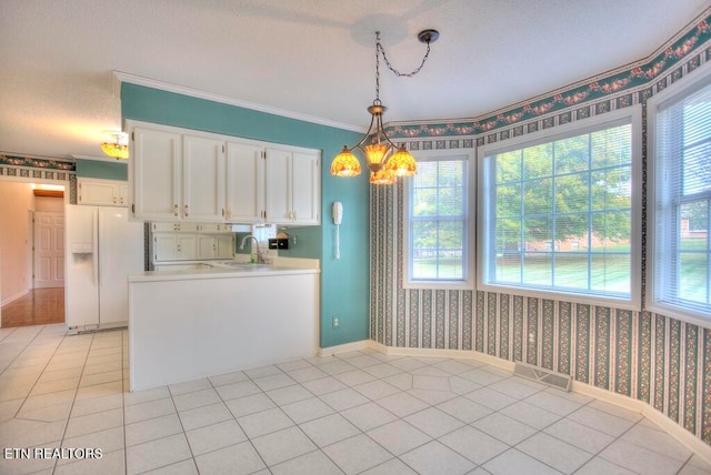 kitchen featuring ornamental molding, white refrigerator with ice dispenser, white cabinetry, light tile patterned floors, and hanging light fixtures