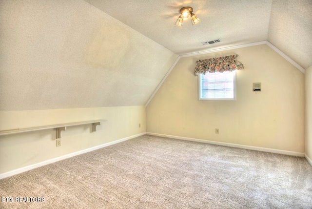 bonus room with a textured ceiling, vaulted ceiling, and carpet flooring